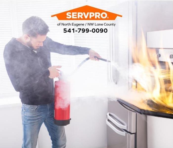 A person uses a fire extinguisher to put out a small kitchen fire.