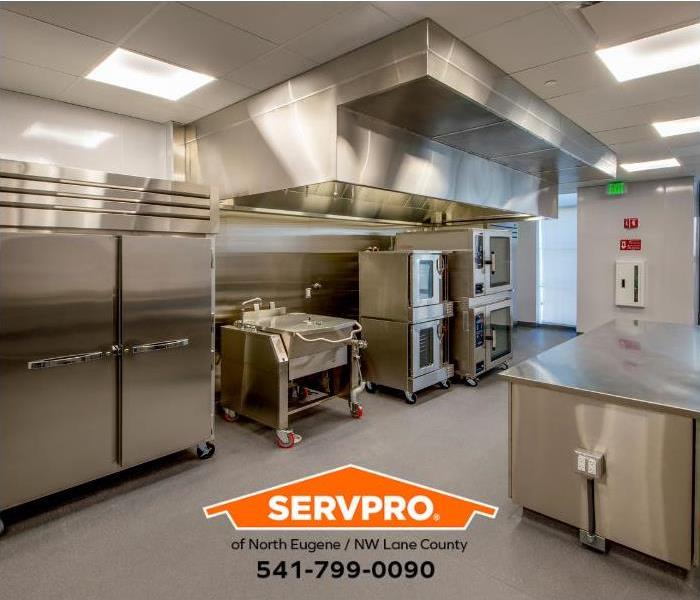 Stainless steel appliances gleam in a kitchen restored from fire damage.